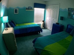 A bedroom with two beds, a nightstand, a lamp, a window with blinds, and a door. - Rebecca 1377 Apartment 4 Bedroom (Haines City)