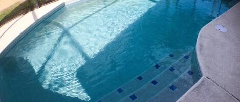 A swimming pool with a tiled edge and a clear blue water surface.