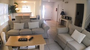 A living room with a sofa, a coffee table, and a lamp.