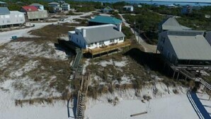 Una propiedad costera con una casa principal, una edificación más pequeña y un muelle.