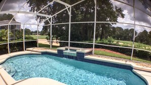 A swimming pool with a clear view of the surrounding landscape, including trees and a grassy area. - Mallory Villa Villa 3 Bedroom (Haines City)