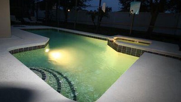 A swimming pool with a tiled edge and a small hot tub area, surrounded by a covered deck. - Calabay Dream Apartment 4 Bedroom (Haines City)