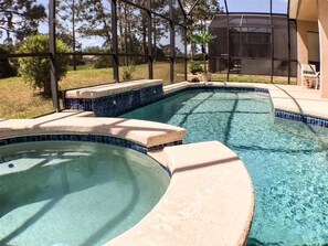 A swimming pool with a curved design and a tiled edge.