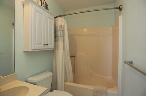 A bathroom with a toilet, sink, and bathtub. - Beach Therapy on the Cape Apartment 3 Bedroom (Port St. Joe)