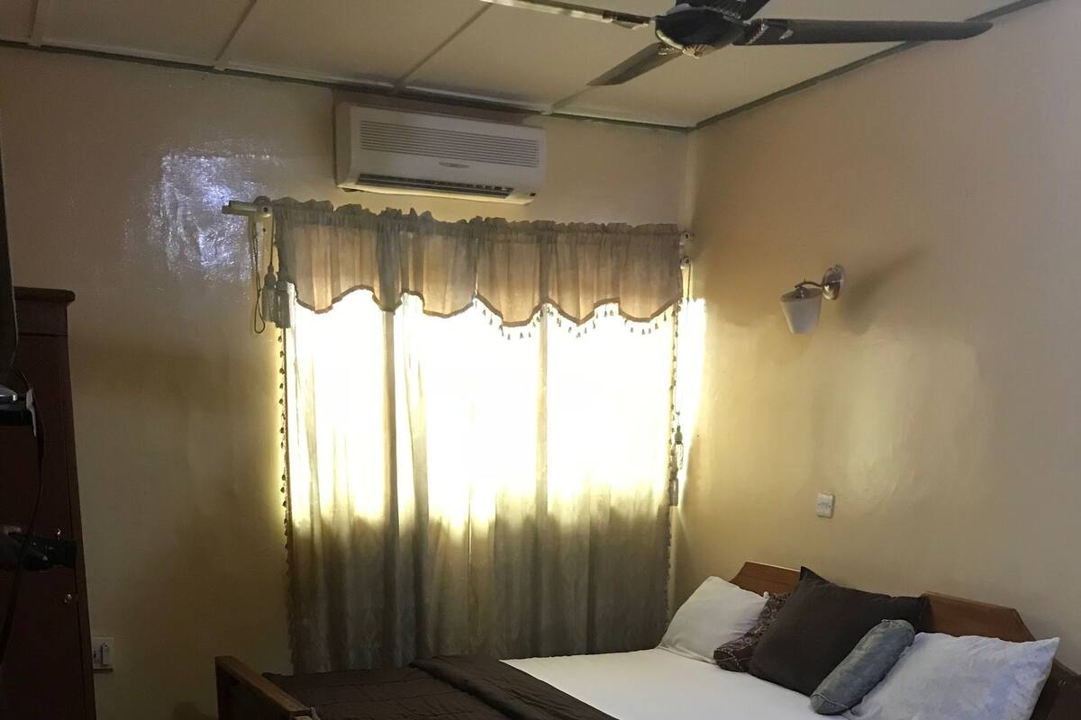 Un dormitorio con una cama individual, un escritorio y un ventilador de techo.