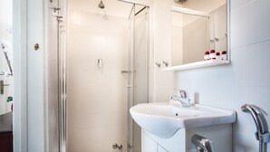 A modern bathroom with a glass shower enclosure, a white sink, and a mirror above the sink. - Casa Micol (Florence)