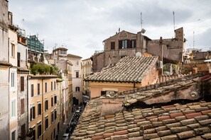 A narrow street between buildings with traditional tiled roofs and balconies.