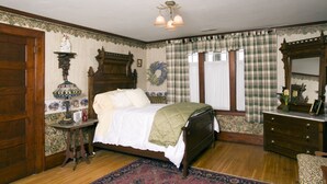 Une chambre à coucher de style traditionnel, avec un lit en bois, une table de chevet, une commode et un miroir.