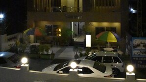 Un edificio de varios pisos con balcones y un área de estacionamiento.