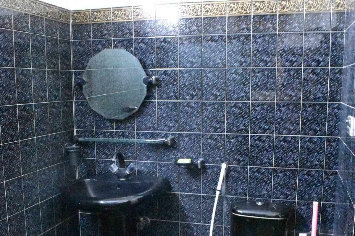 A bathroom with a sink, toilet, and shower area.