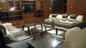 Una sala de estar con un conjunto de sofá, una mesa de centro de vidrio y estanterías empotradas.