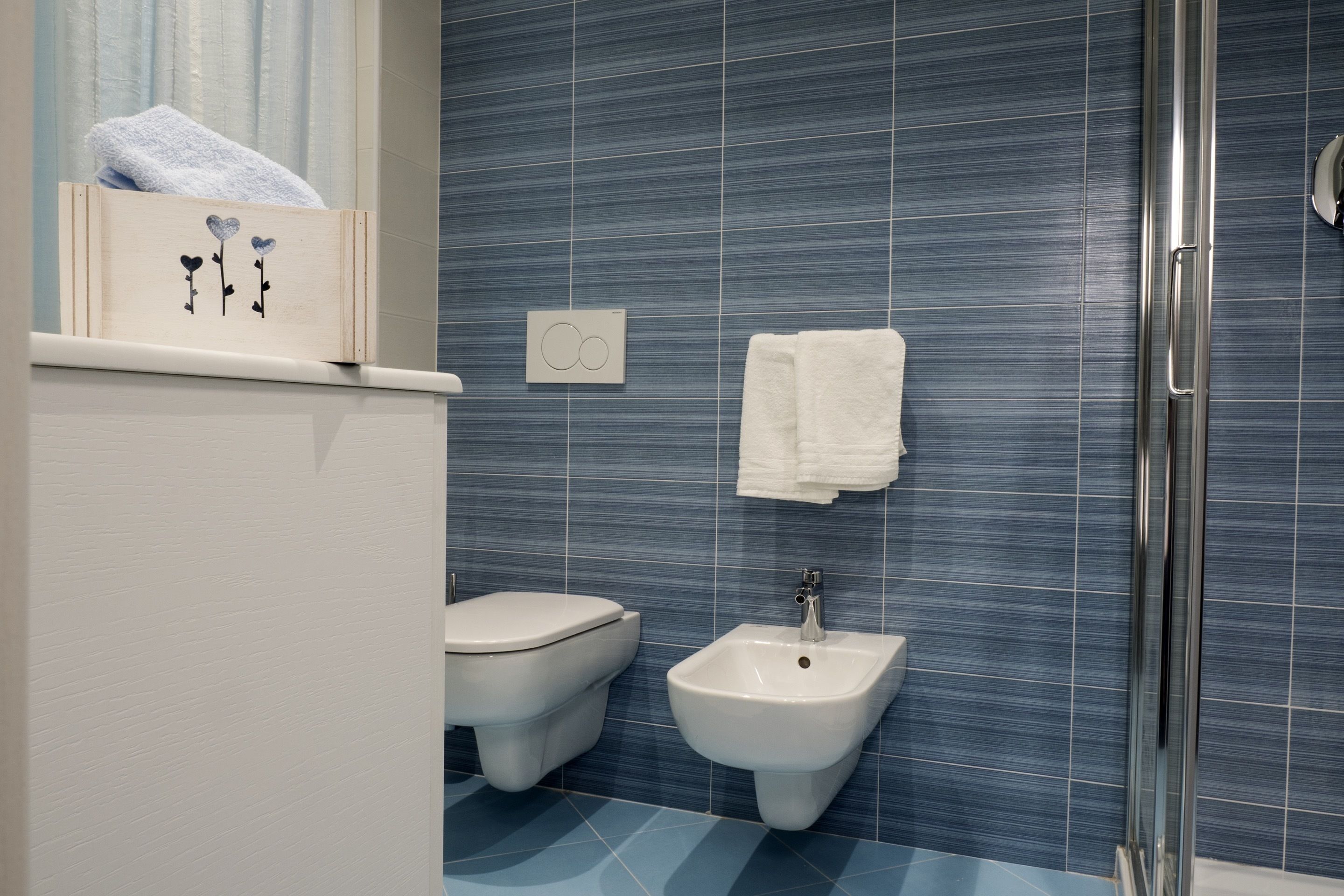 A bathroom with a toilet, bidet, and a glass shower enclosure.