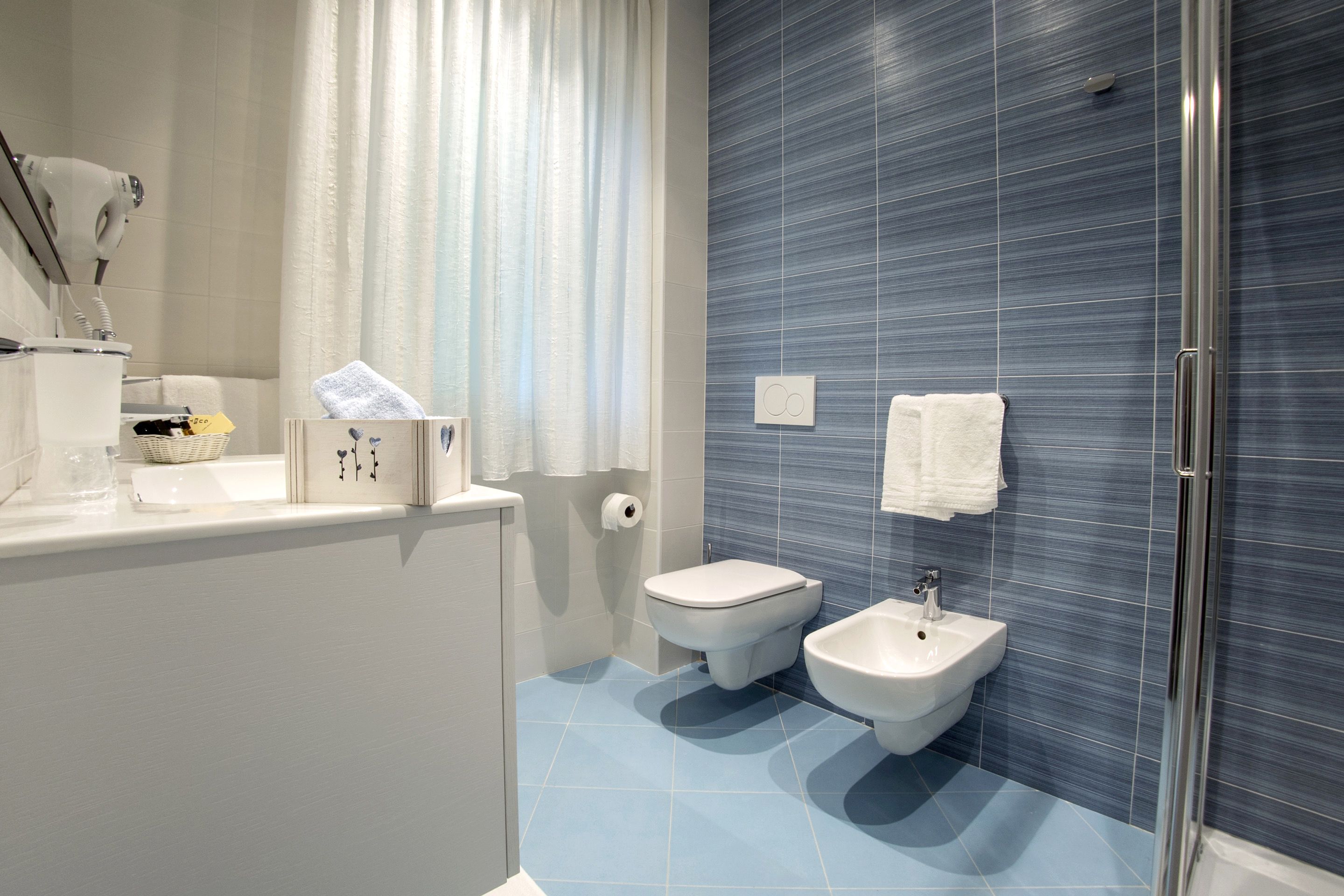 Un baño moderno con inodoro, bidé y lavamanos.