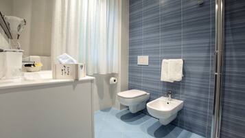 Un baño moderno con inodoro, bidé y lavamanos.