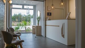 Een modern ontworpen receptiegebied met een receptiebalie, zithoek en uitzicht op de omgeving.