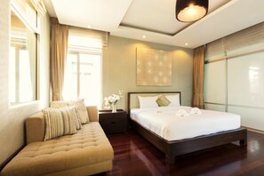 A modern hotel room with a large bed, a seating area, and a large window. - Tropical Garden Paradise Villa (Sattahip)