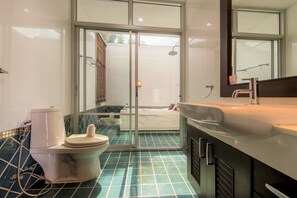 A modern bathroom with a glass shower enclosure, a bathtub, and a toilet. - Tropical Garden Paradise Villa (Sattahip)