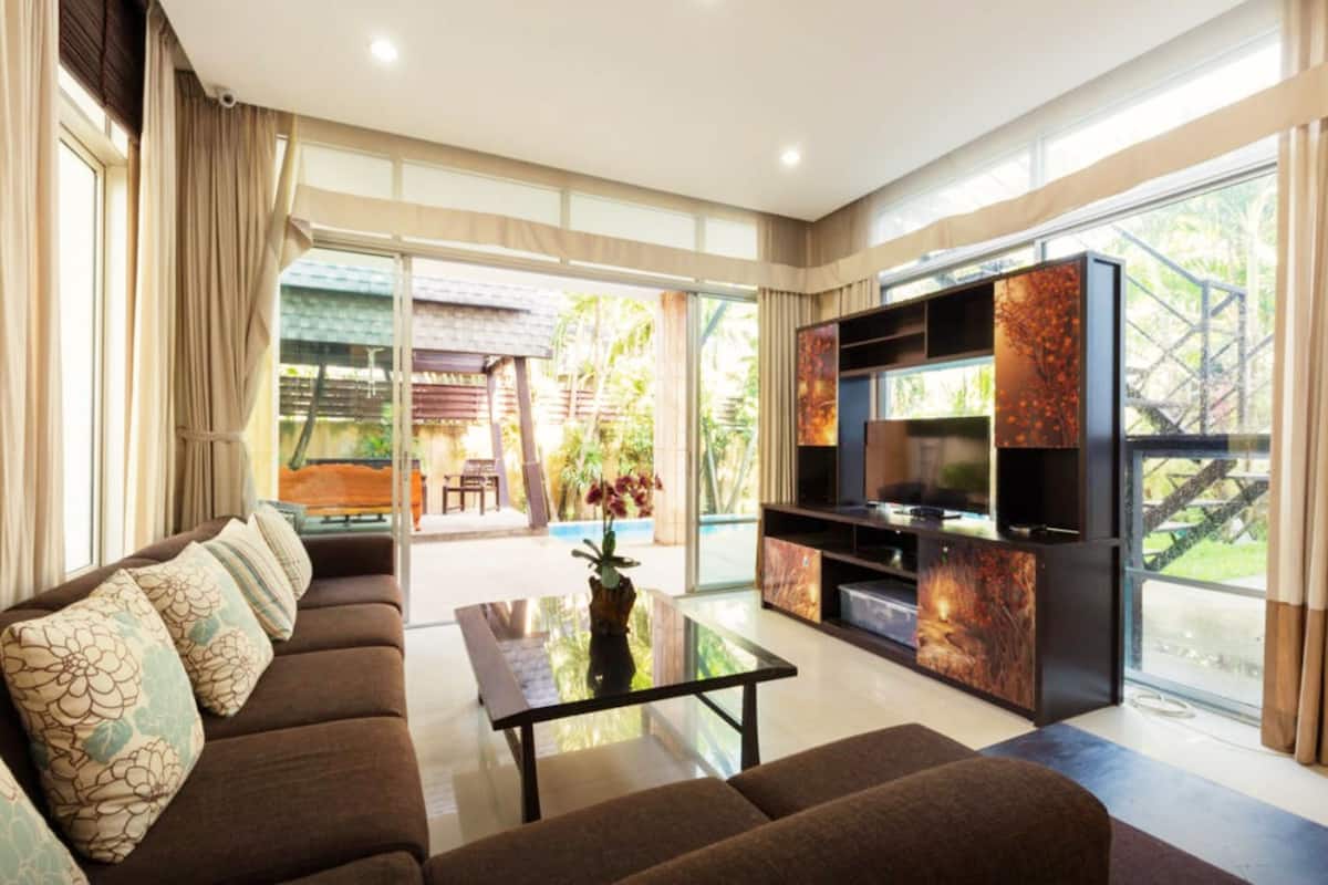 A modern living room with a sofa, coffee table, and entertainment unit.