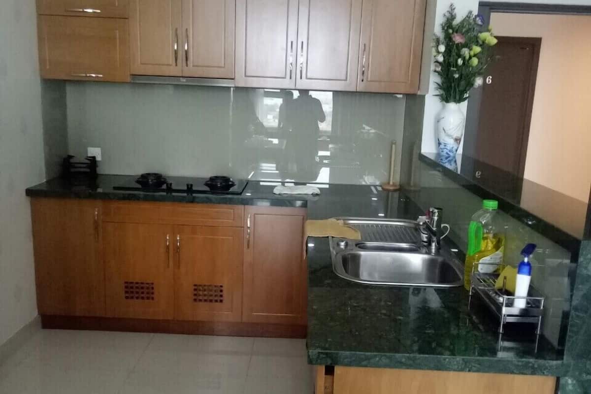 A compact kitchen with wooden cabinets, a stainless steel sink, and a countertop with a few items.