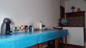 Una habitación con una mesa azul, un globo terráqueo y diversos objetos en la pared.