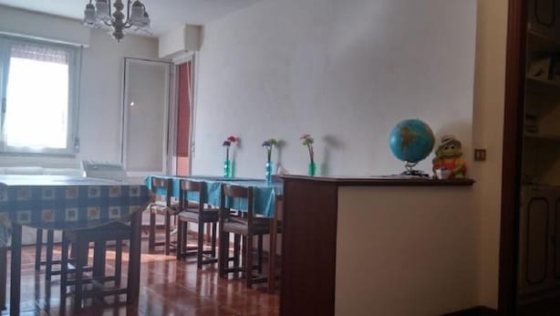 Un área de comedor con una mesa y sillas, un globo terráqueo y una pequeña figura en un estante.