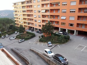 A multi-story residential building with a parking area in front.