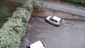 Vista aérea de un estacionamiento con dos autos blancos estacionados.