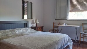 Un dormitorio con cama, escritorio y silla.