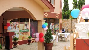 An outdoor area with a brick floor, potted plants, and tables set up for dining.