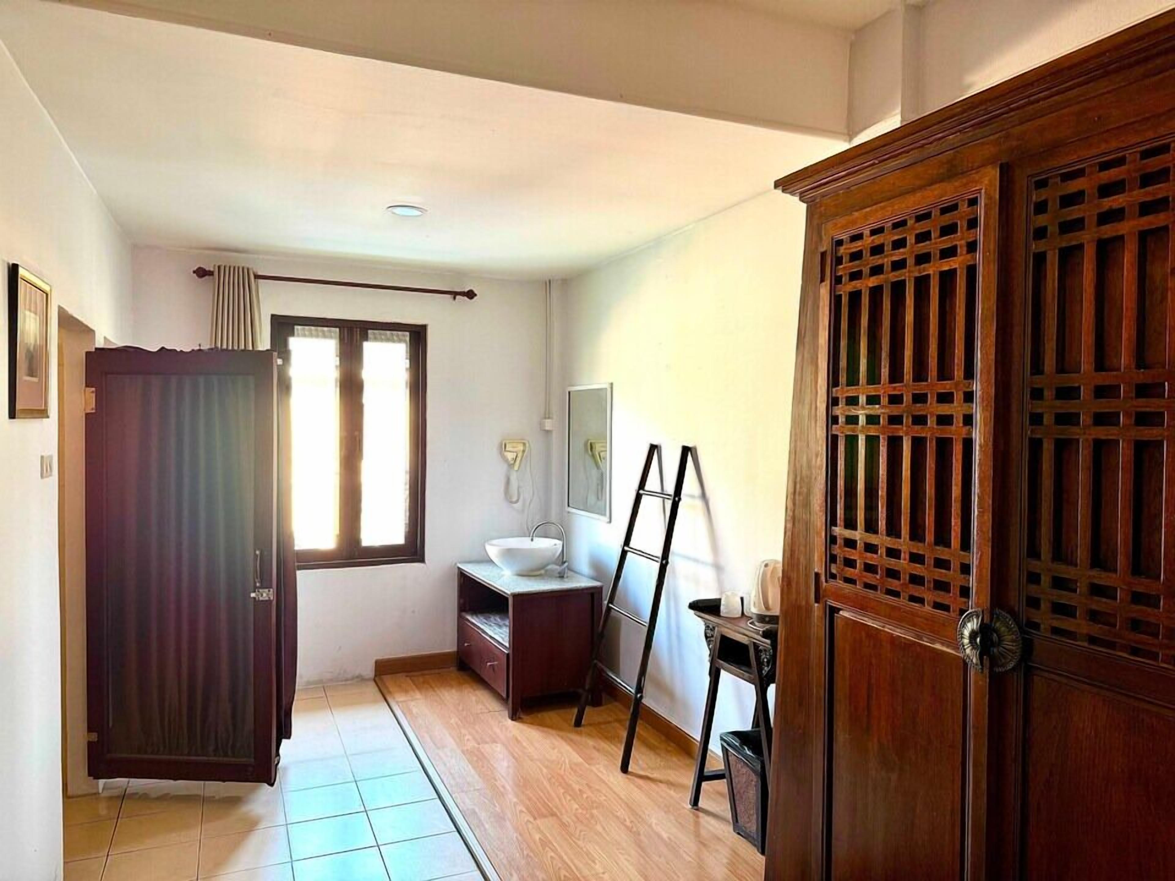 A bathroom with a wooden cabinet, a sink, and a mirror.