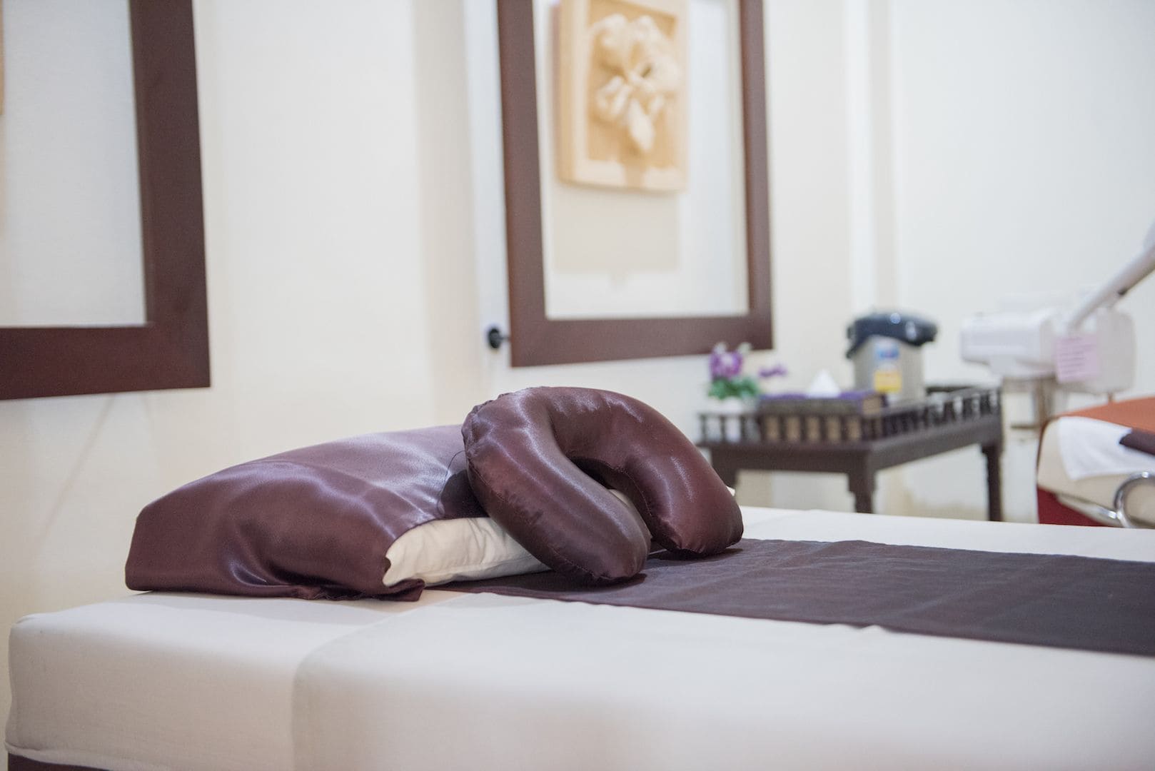 A bed with a white mattress and two brown pillows.