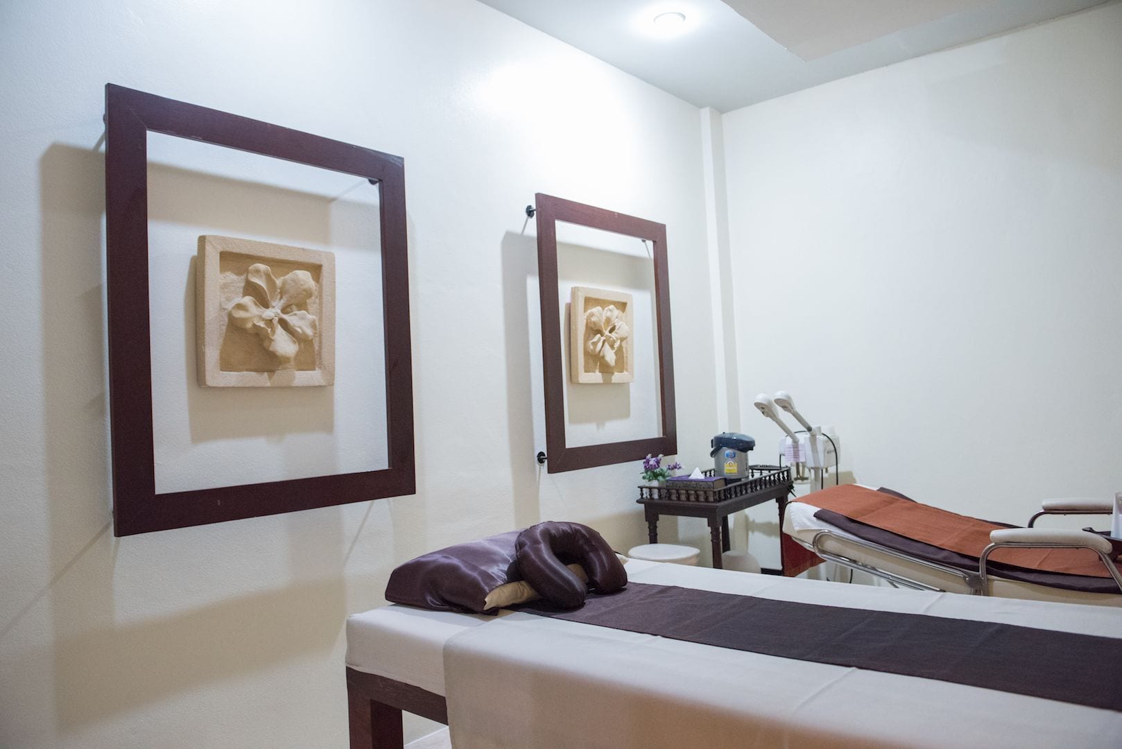 A clinical examination room with a bed, examination table, and medical equipment.