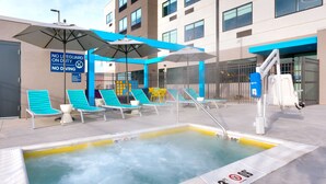 A rooftop pool area with lounge chairs and umbrellas, a no diving sign, and a lifeguard chair. - Tru By Hilton St George, UT (St. George)