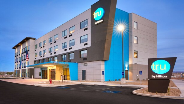 A modern hotel with a prominent 'tru by Hilton' sign, multiple floors, and a parking lot. - Tru By Hilton St George, UT (St. George)