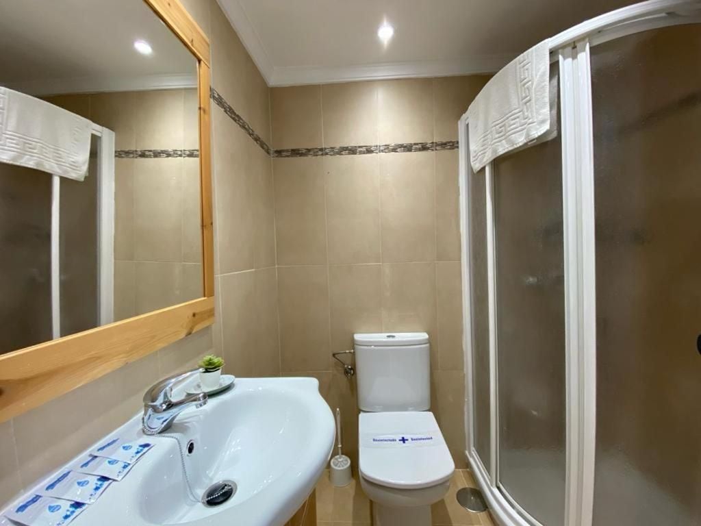 A bathroom with a sink, toilet, and shower.