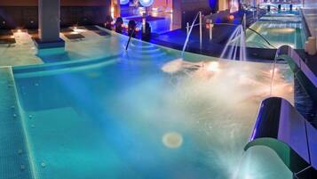 Ein Wellnessbereich mit großem Pool, mehreren Whirlpools und einem Wasserspiel.