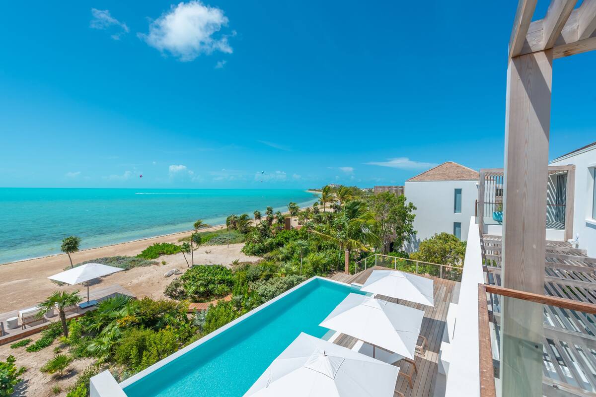 A pool with a view of the beach and ocean.