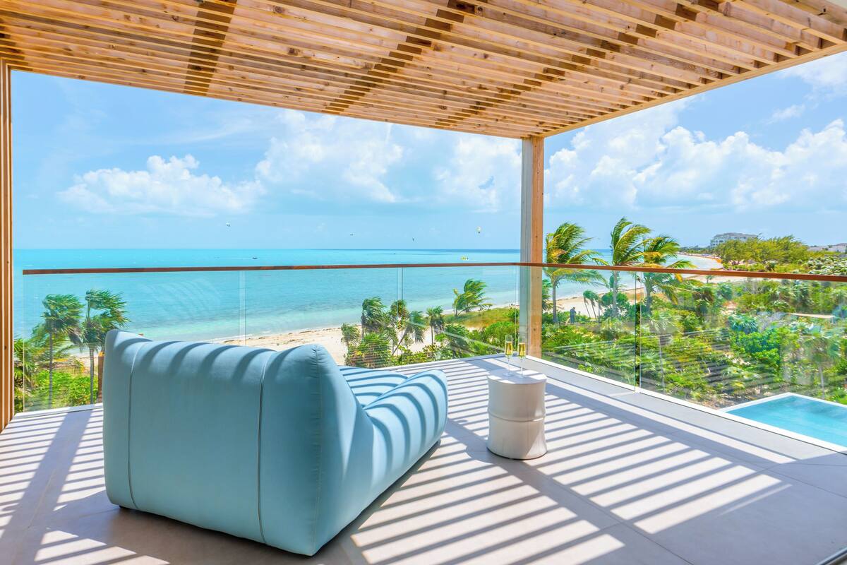 A balcony with a view of the beach and ocean.