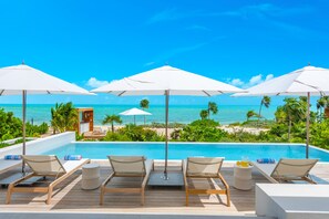 Alberca al aire libre, sombrillas en la alberca y camastros 