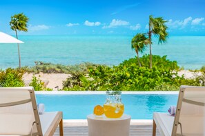 Una piscina al aire libre, sombrillas, sillones reclinables de piscina