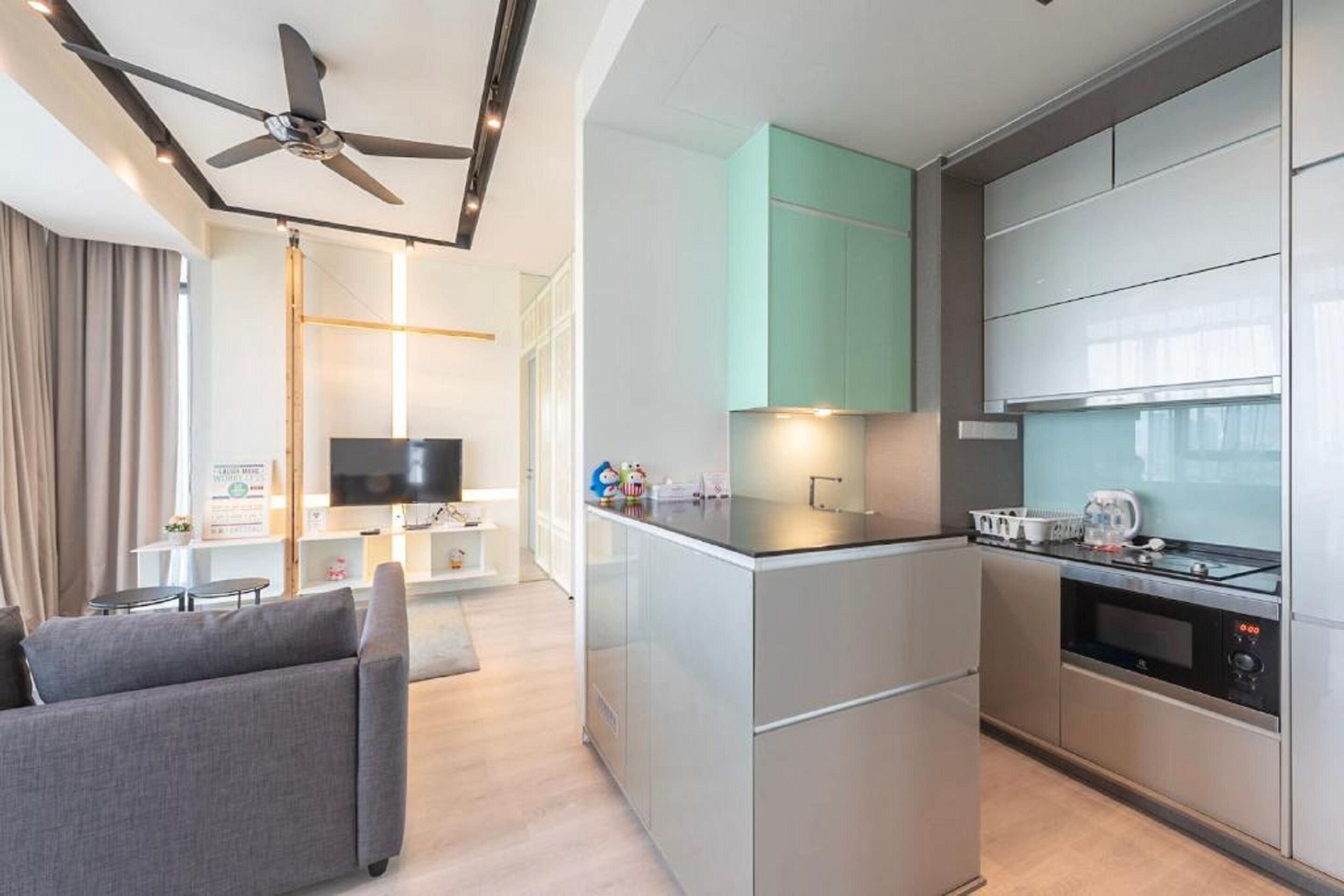 A modern kitchen with a central island, built-in appliances, and a ceiling fan.