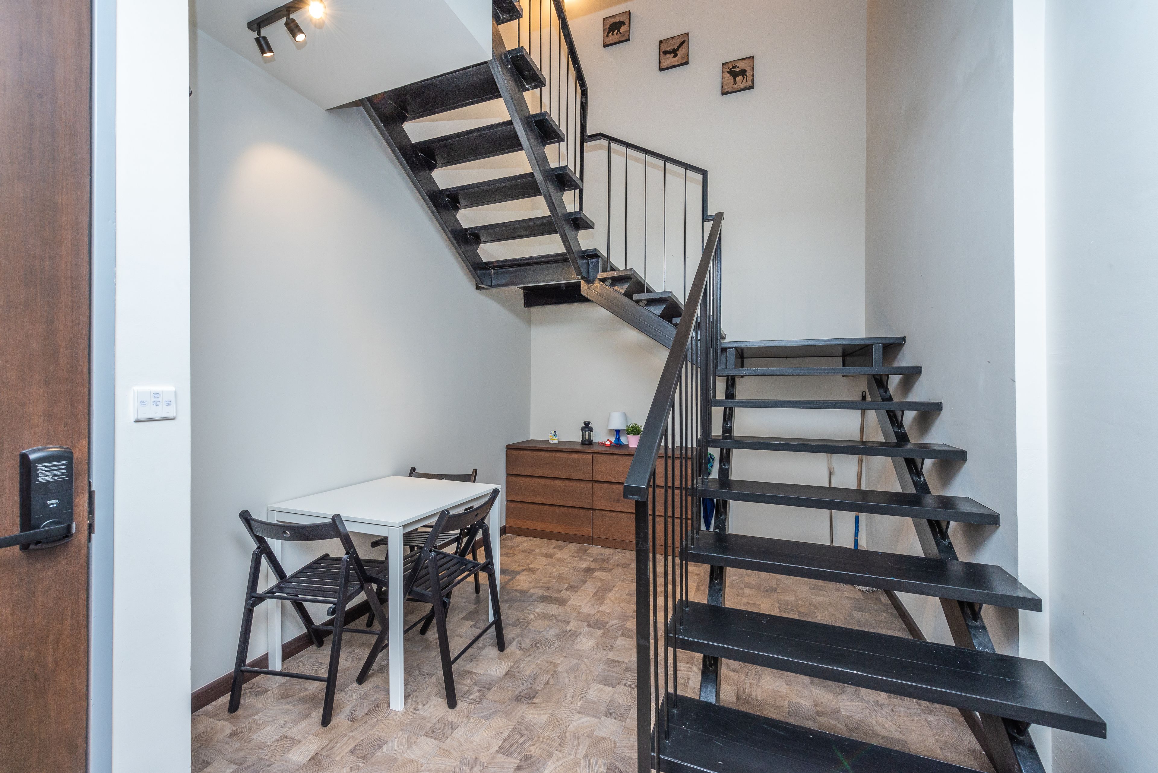Een modern interieur met een trap, een eethoek en een kleine keuken.