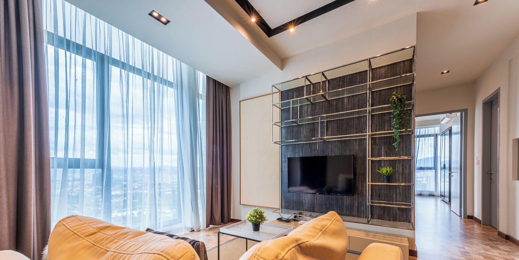 A modern living room with a large TV, a sofa, and a coffee table.