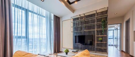 A modern living room with a large TV, a sofa, and a coffee table.