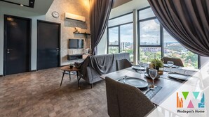 Ein modernes Wohnzimmer mit Essbereich, großen Fenstern und Blick auf die Stadt.