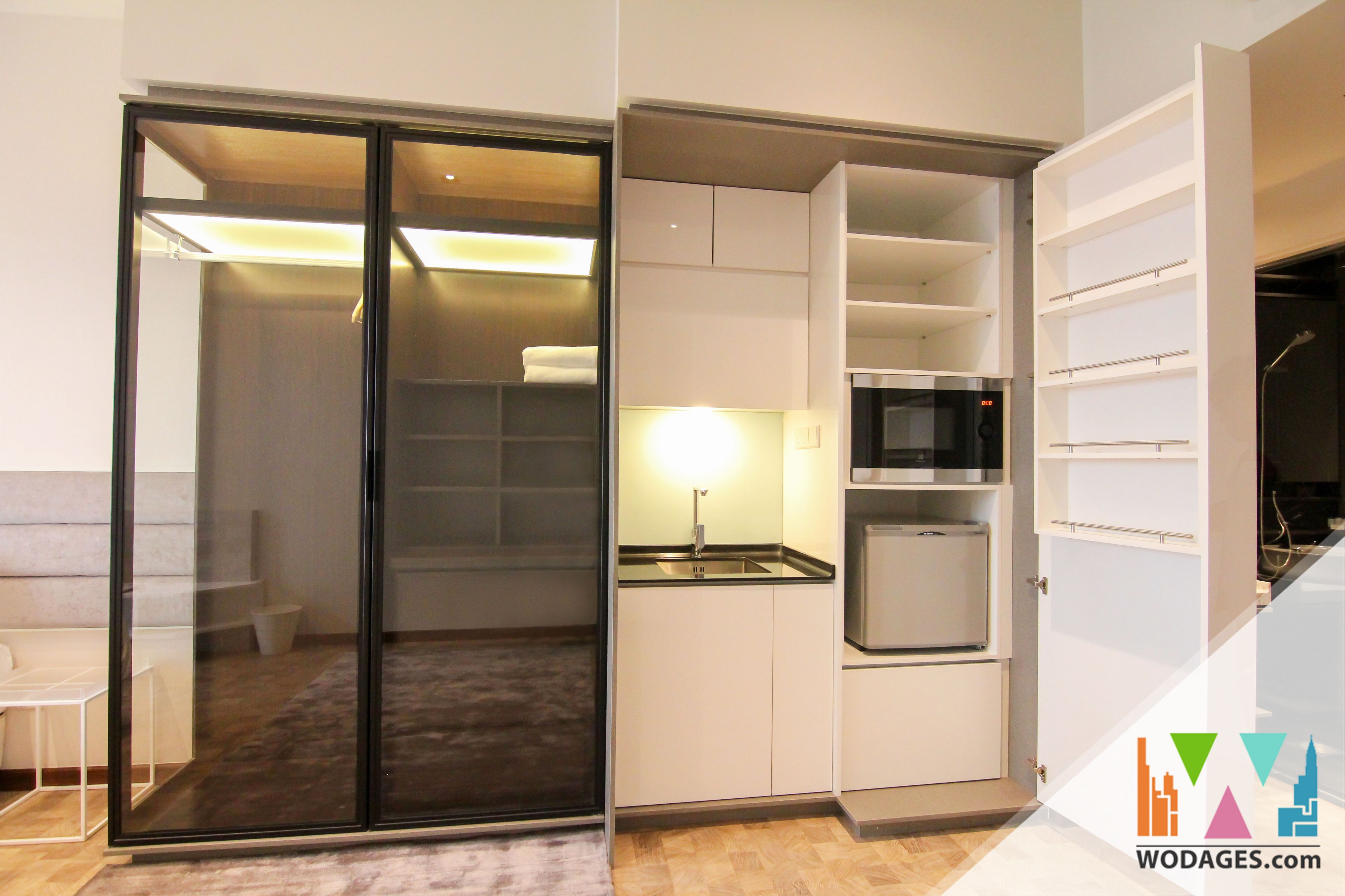 A compact kitchen with a microwave, a sink, and a cabinet.