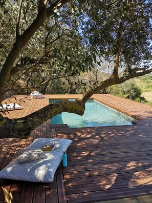 A wooden deck with a pool, surrounded by trees. - Biovilla Sustentabilidade (Palmela)