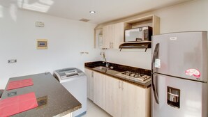 Apartamento, 1 quarto | Cozinha americana privada | Geladeira, micro-ondas, fogão, cooktop