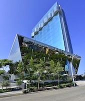 Um edifício moderno com fachada de vidro refletante e design angular distinto.