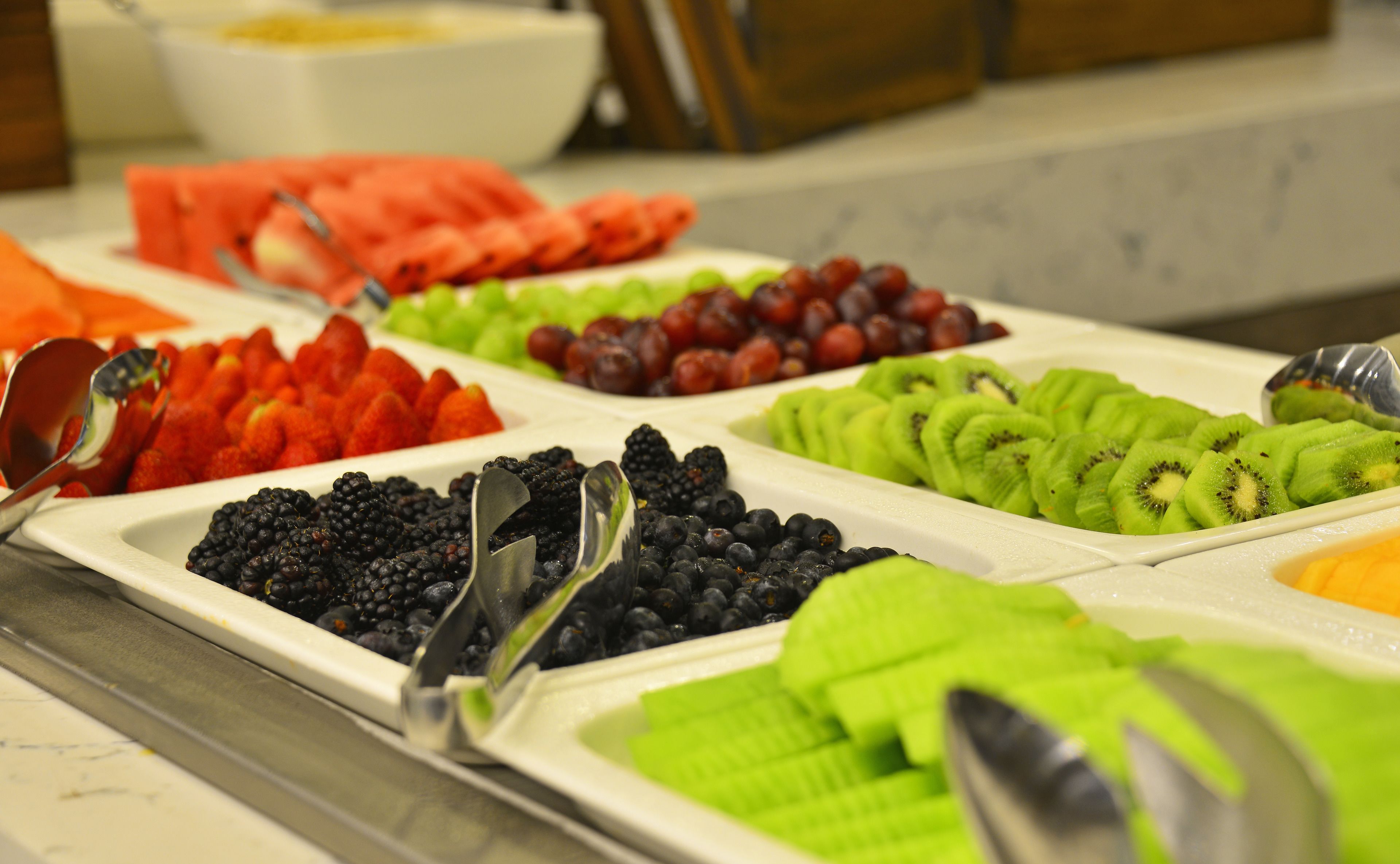 A buffet with various fruits and vegetables.